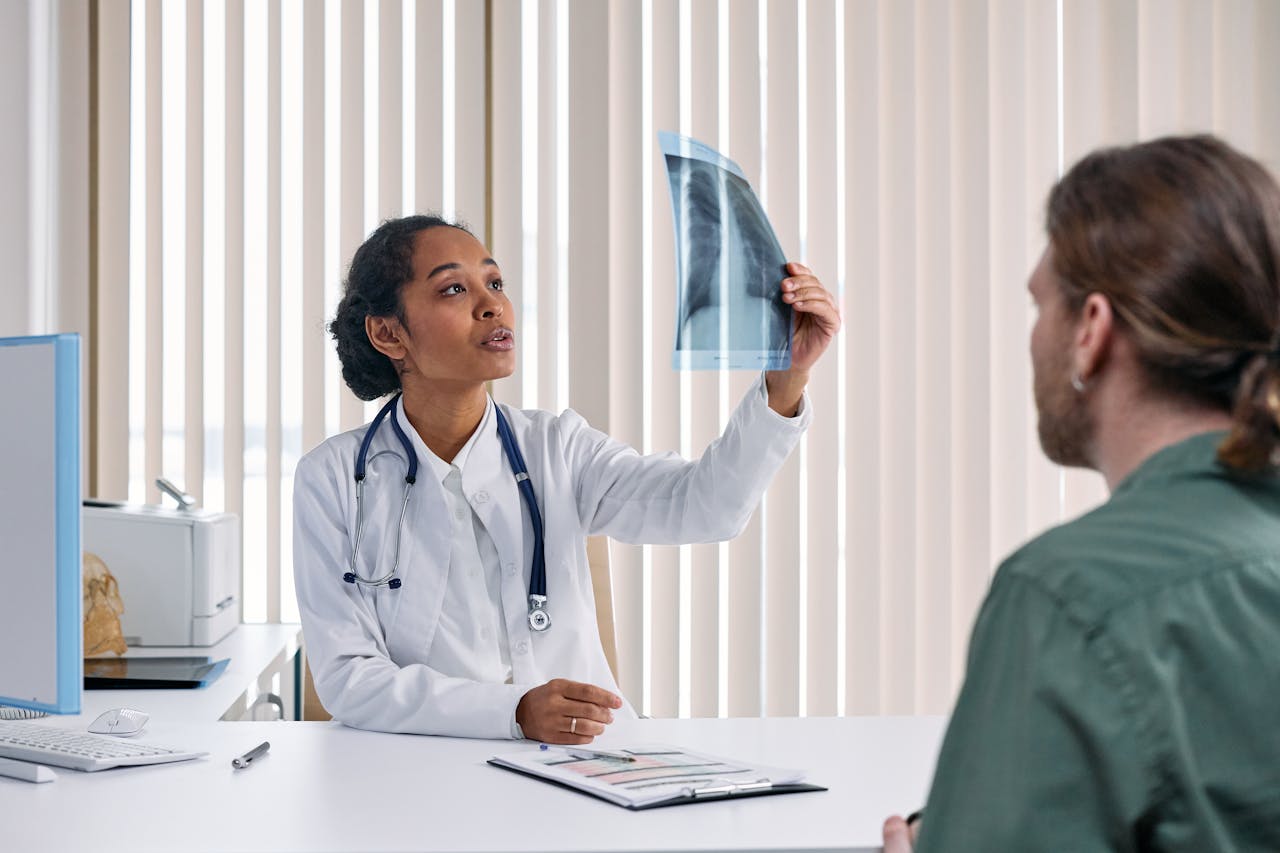 portfolio-05 Female doctor examines x-ray results with male patient in a medical setting.